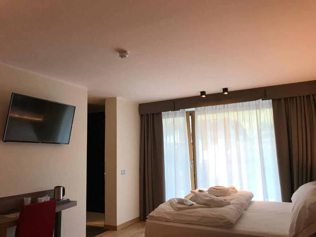 Двухместный (Улучшенный двухместный номер с 1 кроватью или 2 отдельными кроватями) отеля Dolomeet Boutique Hotel, Мадонна-ди-Кампильо