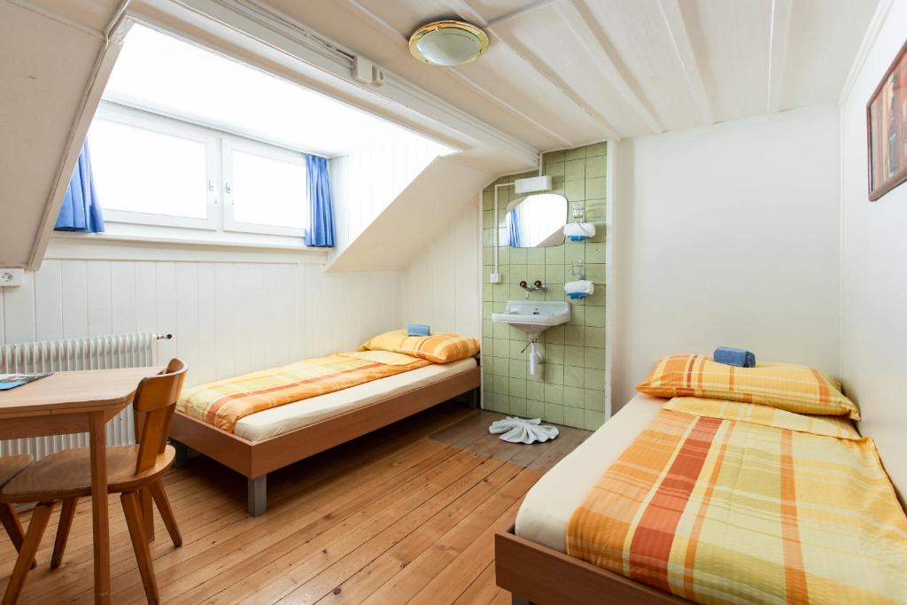 Двухместный (Двухместный номер с 2 отдельными кроватями и общей ванной комнатой) хостела Happy Inn Lodge, Интерлакен